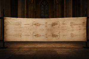 Langgestrecktes Leinentuch mit einer schwach sichtbaren Vorder- und Rueckenansicht eines maennlichen Koerpers in gedaempfter Kapellenbeleuchtung, ohne Schrift oder Logos.